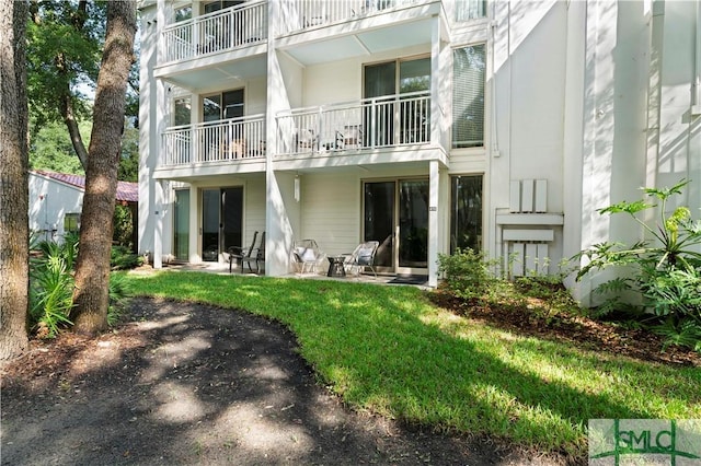 back of property featuring a patio area and a lawn