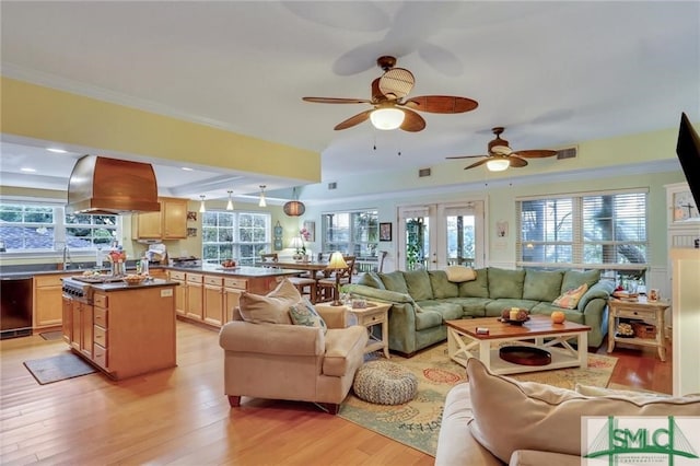 living room featuring ornamental molding, plenty of natural light, light hardwood / wood-style floors, and french doors