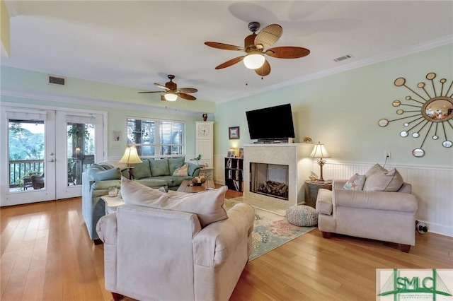 living room with light hardwood / wood-style flooring, ornamental molding, and french doors