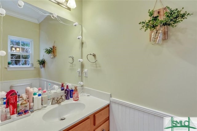 bathroom featuring vanity, crown molding, and toilet