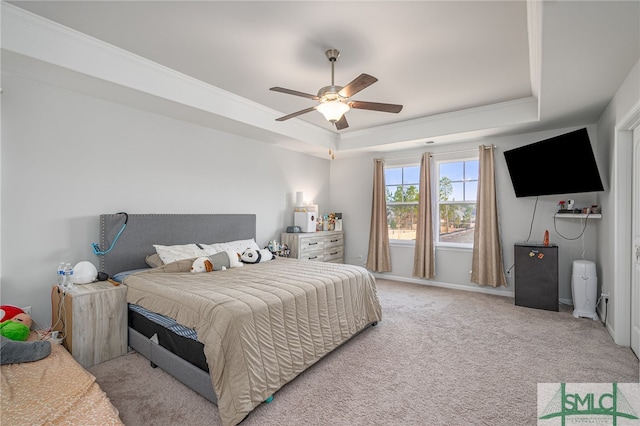 carpeted bedroom featuring crown molding, ceiling fan, and a tray ceiling