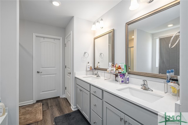 bathroom with hardwood / wood-style flooring, vanity, and a shower