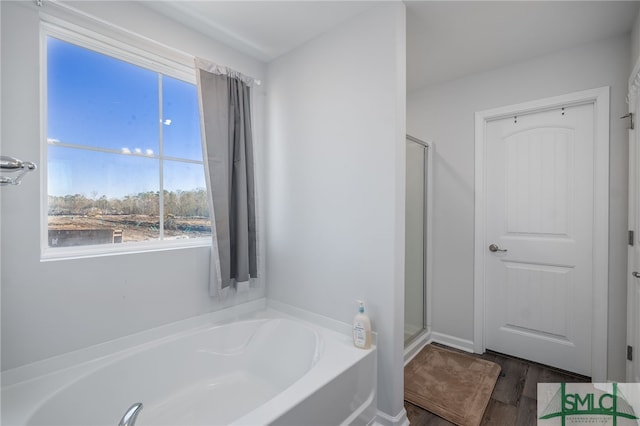 bathroom featuring wood-type flooring and separate shower and tub