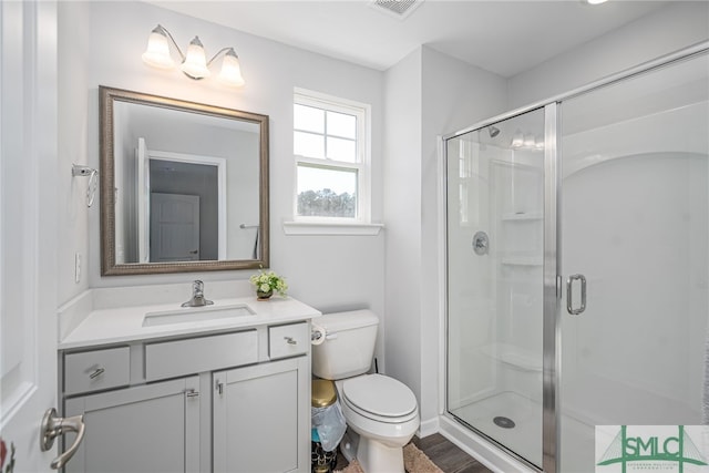 bathroom with a shower with door, vanity, and toilet