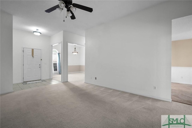 unfurnished living room featuring ceiling fan and light carpet