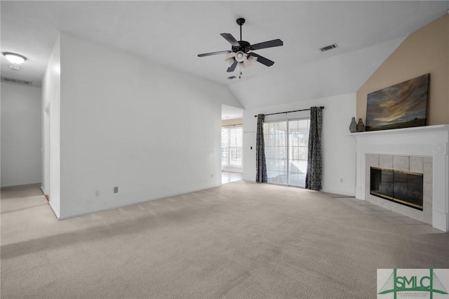 unfurnished living room with ceiling fan, light colored carpet, lofted ceiling, and a tiled fireplace