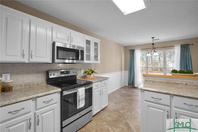 kitchen featuring white cabinetry, appliances with stainless steel finishes, and pendant lighting