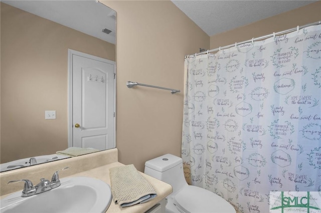 bathroom featuring vanity, toilet, a shower with shower curtain, and a textured ceiling