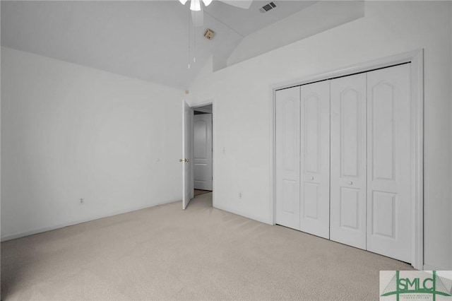 unfurnished bedroom featuring high vaulted ceiling, light colored carpet, a closet, and ceiling fan