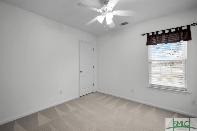 spare room with ceiling fan and carpet