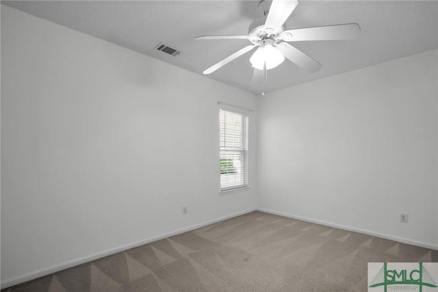 unfurnished room featuring ceiling fan, light carpet, and a textured ceiling