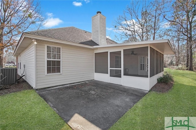 back of property featuring a patio, central air condition unit, a sunroom, and a lawn