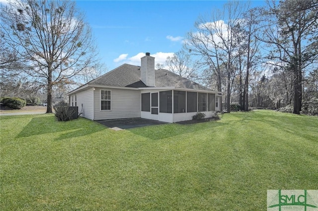 rear view of property featuring a sunroom and a lawn