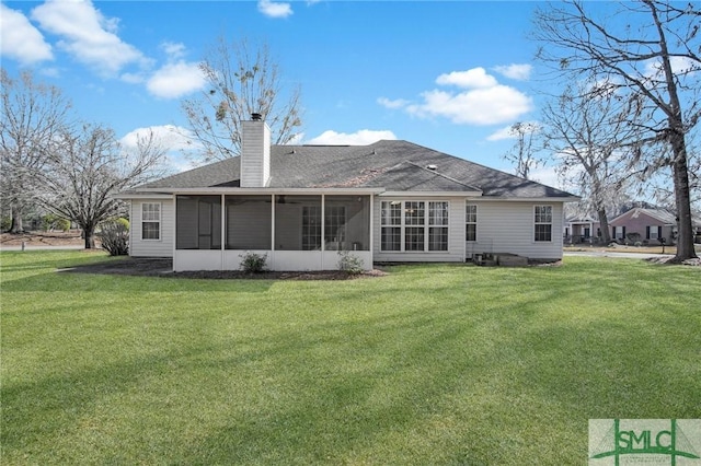 back of property with a sunroom and a lawn