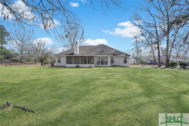 rear view of house featuring a sunroom and a yard