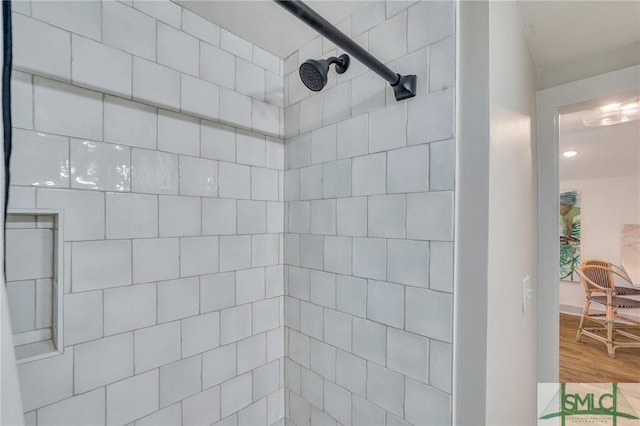 full bathroom featuring a tile shower and wood finished floors