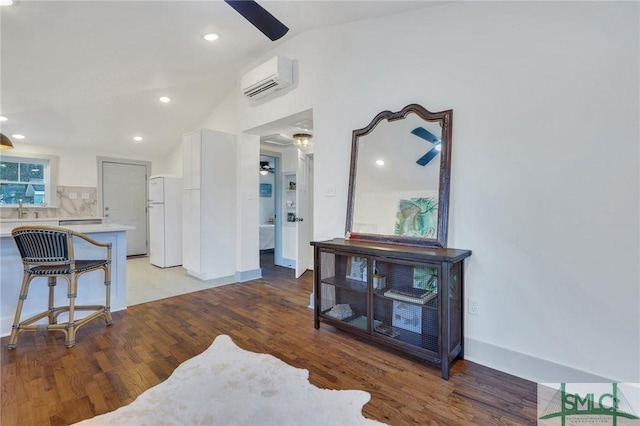 interior space with recessed lighting, a sink, vaulted ceiling, light wood-style floors, and a wall mounted air conditioner