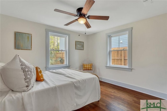 bedroom featuring dark wood finished floors, baseboards, and ceiling fan