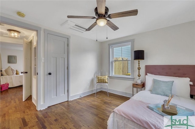 bedroom featuring baseboards, wood finished floors, and a ceiling fan