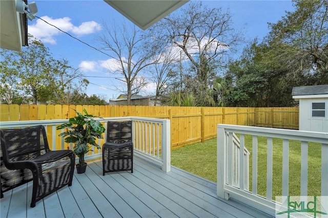 wooden terrace with a lawn and a fenced backyard