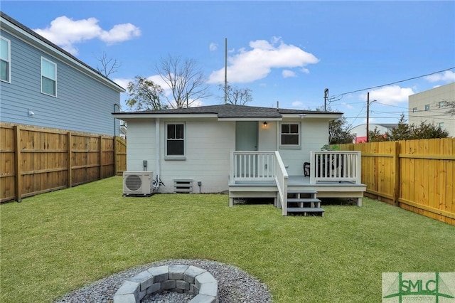 rear view of property featuring an outdoor fire pit, a fenced backyard, a deck, ac unit, and a lawn