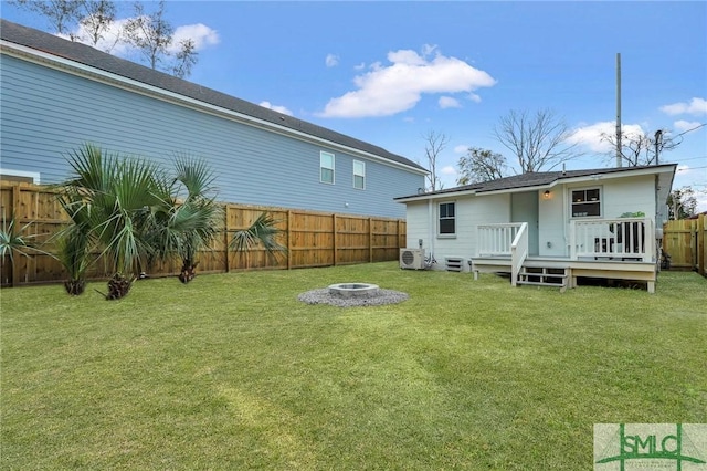 back of house with a wooden deck, an outdoor fire pit, ac unit, a yard, and a fenced backyard