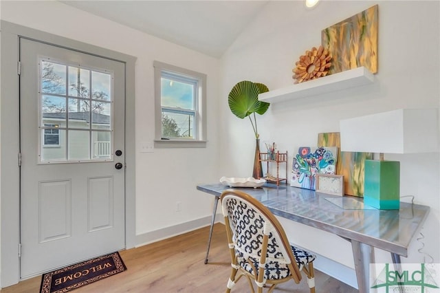 interior space with wood finished floors, baseboards, and vaulted ceiling