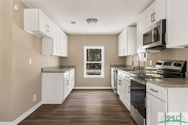 kitchen with appliances with stainless steel finishes, dark hardwood / wood-style floors, sink, and white cabinets