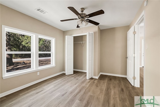 unfurnished bedroom with ceiling fan, light wood-type flooring, and a closet