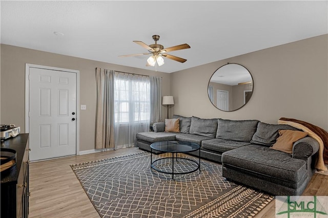 living room with light hardwood / wood-style floors and ceiling fan