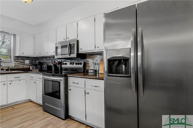 kitchen with sink, stainless steel appliances, tasteful backsplash, light hardwood / wood-style floors, and white cabinets