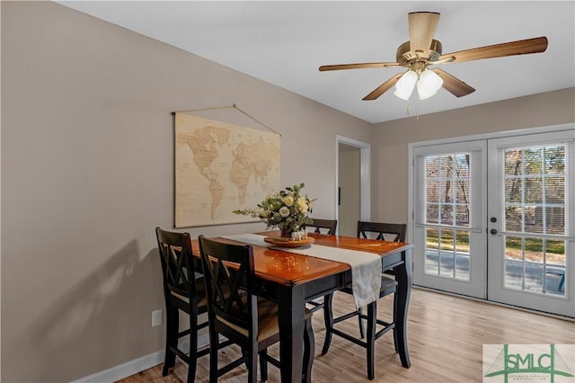 dining room with ceiling fan, light wood-type flooring, and french doors