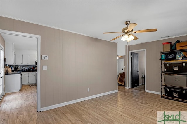 unfurnished living room with crown molding, ceiling fan, and light wood-type flooring