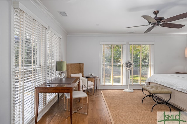 bedroom with ornamental molding, wood-type flooring, and visible vents