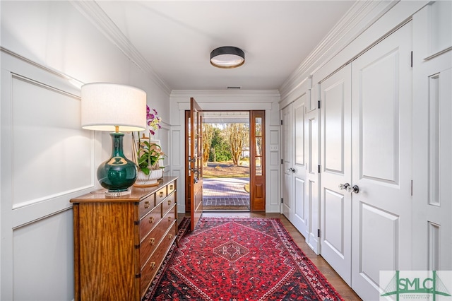 foyer featuring ornamental molding and wood finished floors