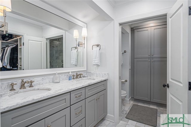 full bath with double vanity, a stall shower, toilet, and a sink