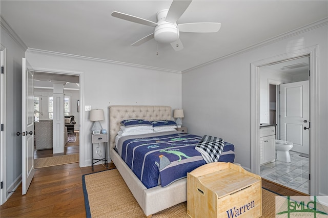 bedroom with crown molding, ensuite bath, decorative columns, and wood finished floors