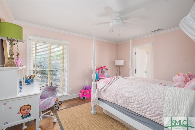 bedroom with crown molding, visible vents, ceiling fan, wood finished floors, and baseboards