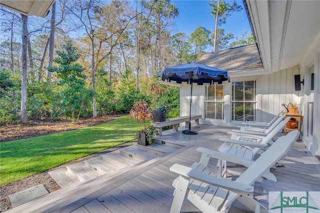 wooden terrace featuring a yard