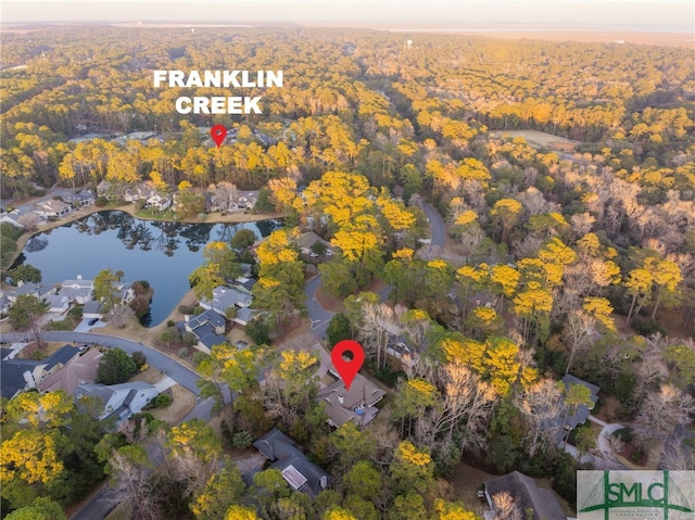 aerial view with a water view and a forest view