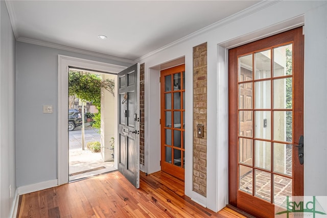 entryway featuring ornamental molding and light hardwood / wood-style floors