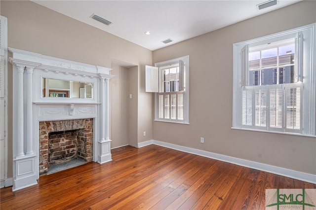 unfurnished living room featuring wood-type flooring and a wealth of natural light