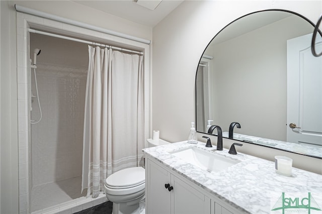 bathroom with toilet, vanity, and walk in shower