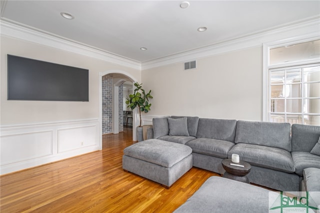 living room featuring hardwood / wood-style floors and crown molding