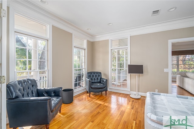 living area featuring crown molding and wood-type flooring