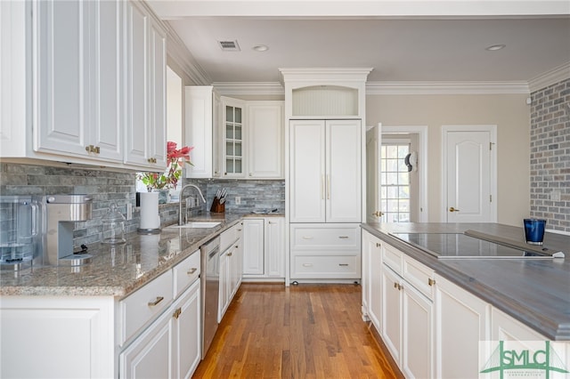 kitchen with sink, hardwood / wood-style floors, white cabinets, and black electric cooktop