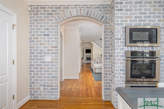 corridor with hardwood / wood-style flooring and crown molding