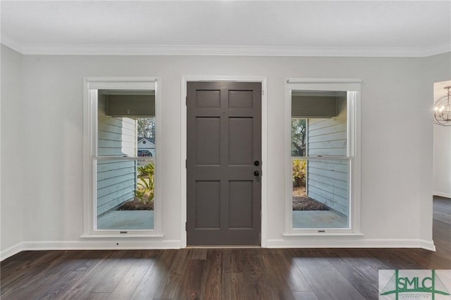 foyer entrance featuring an inviting chandelier, dark hardwood / wood-style flooring, and crown molding