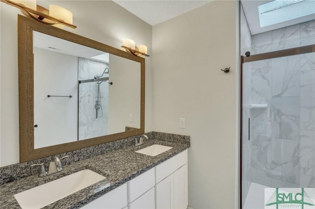 bathroom featuring a shower with door and vanity