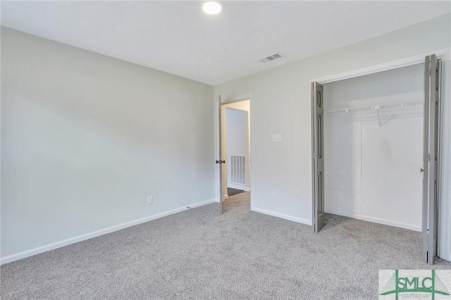 unfurnished bedroom featuring light carpet and a closet